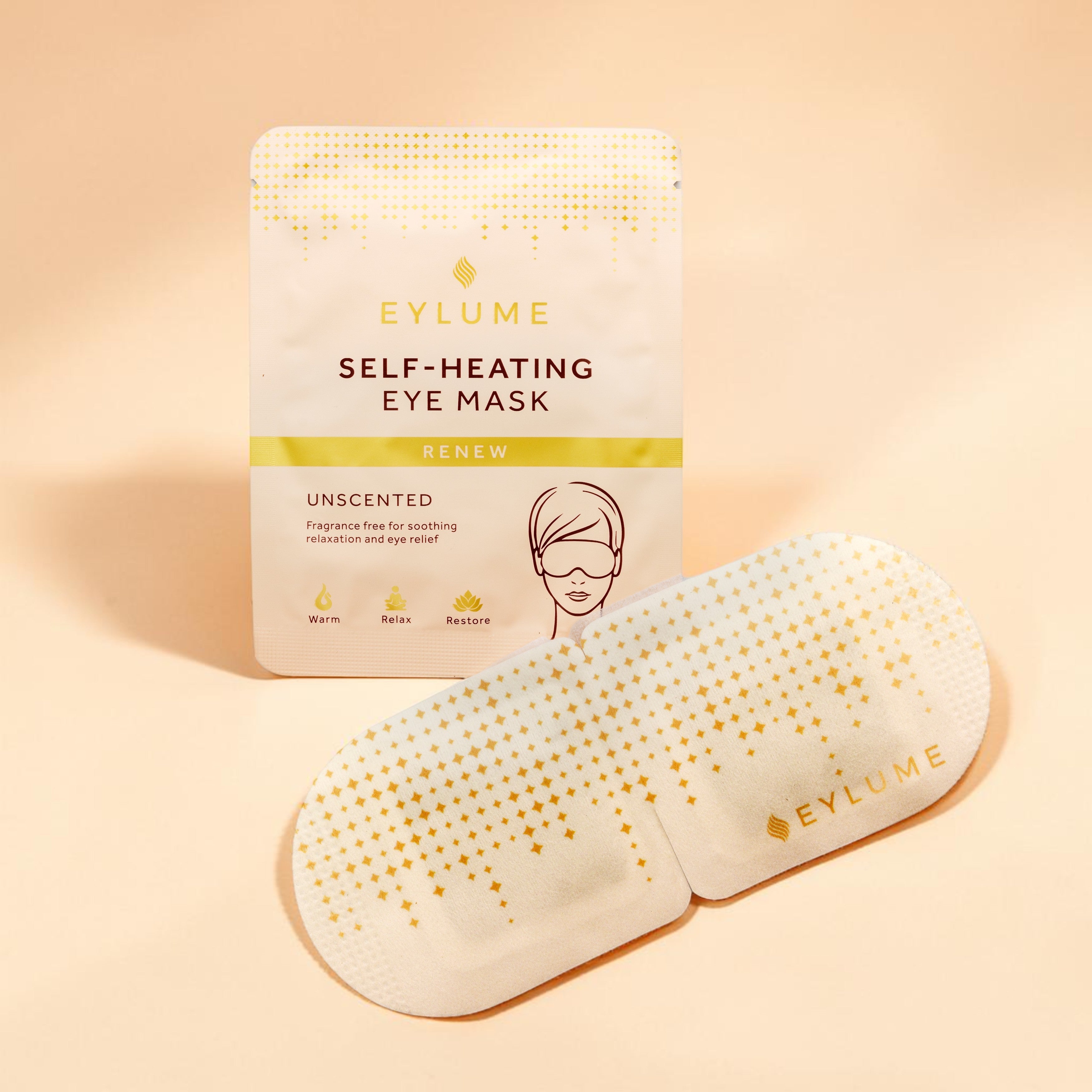 EYLUME Renew Unscented Self Heating Eye Mask sachet and warming eye mask displayed on a soft peach studio background. Fragrance free eye mask designed to relax, soothe tired eyes and support moments of calm.