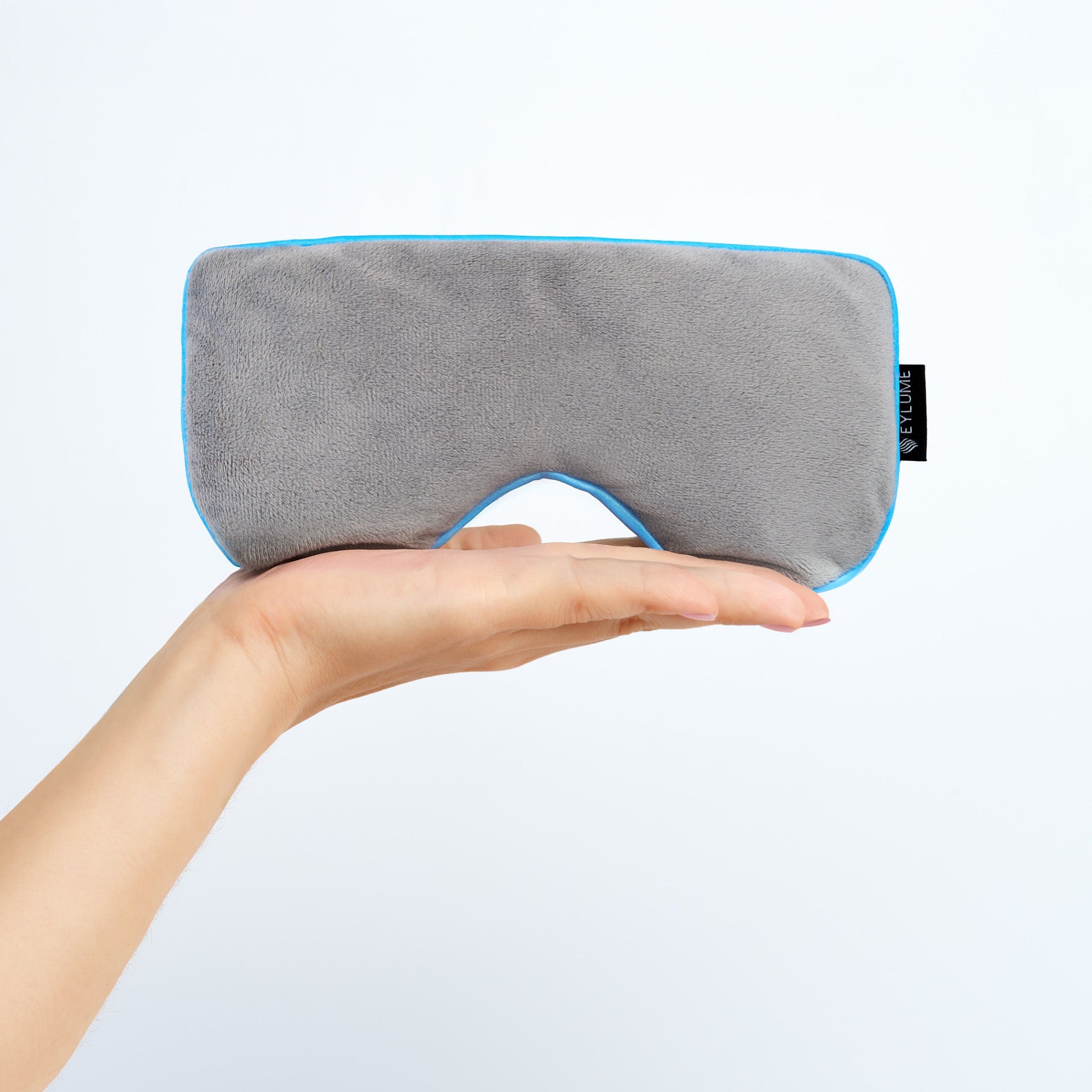 EYLUME Calm Heated Eye Mask held in hand, showing its soft plush texture and ergonomic design