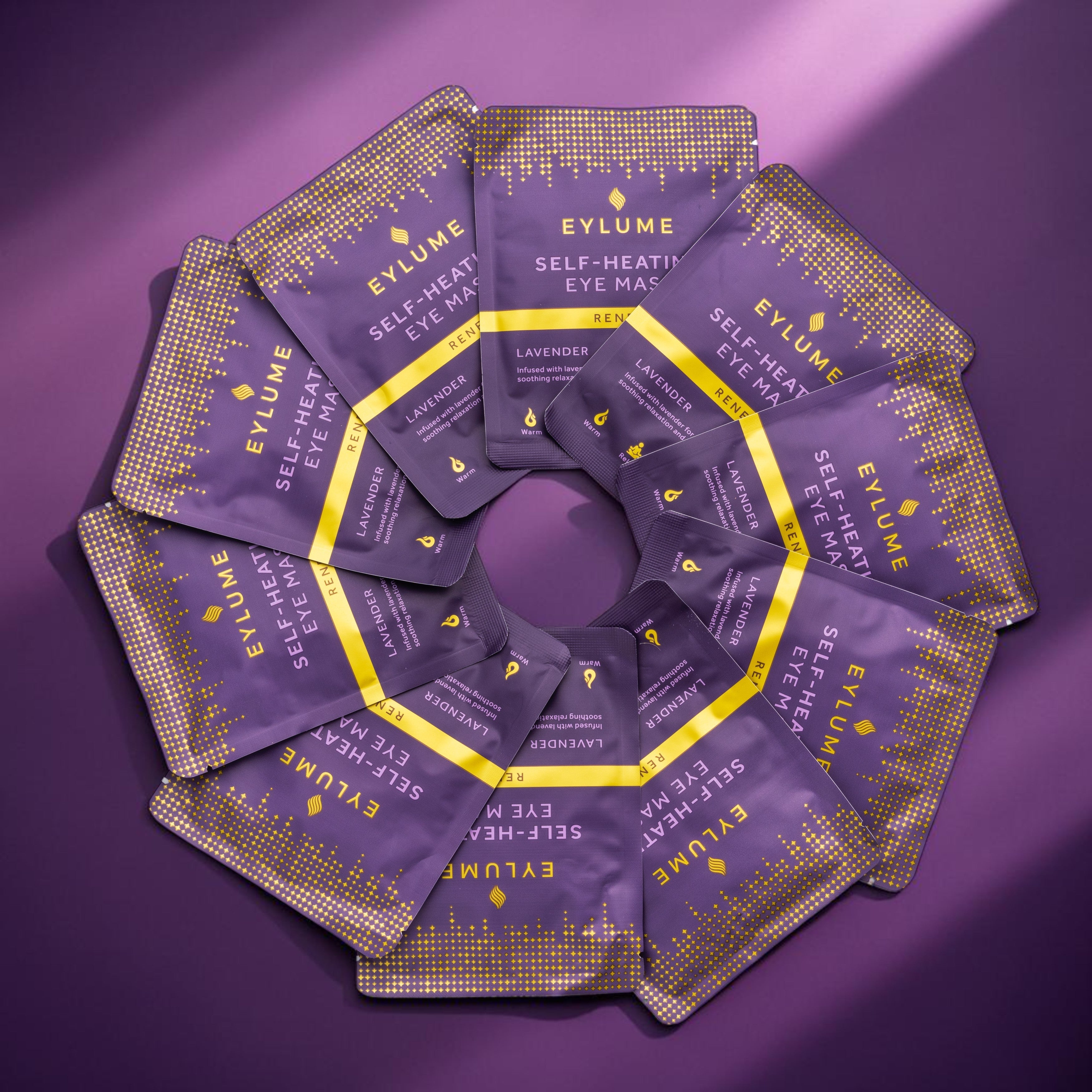 EYLUME RENEW lavender self-heating eye masks arranged in a circular pattern showcasing the packaging design and single-use masks.